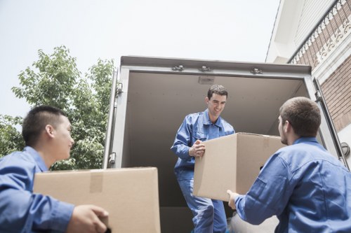 Removalists handling packed boxes and furniture inside a Hanworth property
