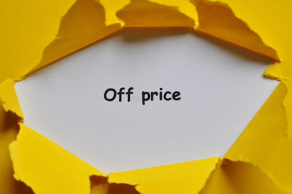 A close-up of a piece of torn yellow paper revealing a white note with the words 'Good Price' typed in black text. The torn paper edges are uneven and curled, creating a jagged frame around the note. The background is a solid yellow surface, and the lighting casts distinct shadows from the torn edges onto the background. This image illustrates concepts related to affordable house removals and packing services, with a focus on transparent pricing for home relocation, as offered by Man with Van Hanworth, a professional company specializing in removals and furniture transport within the moving logistics process.